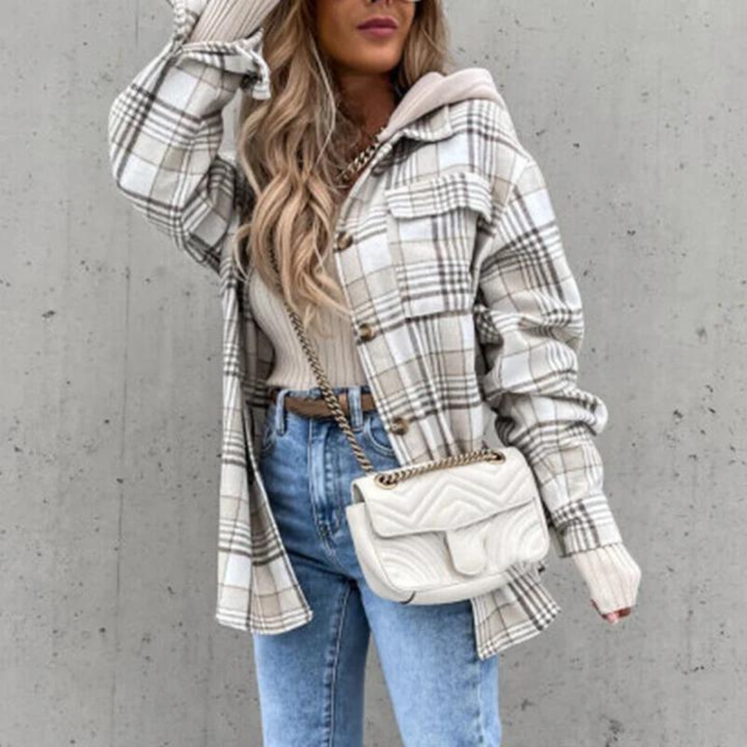 Henco trendy jas in lichtgrijze ruitprint. Deze warme jas heeft een casual oversized pasvorm en is perfect voor het najaar. De jas is stijlvol gecombineerd met een lichte top, jeans en een crossbody tas voor een complete herfstlook.