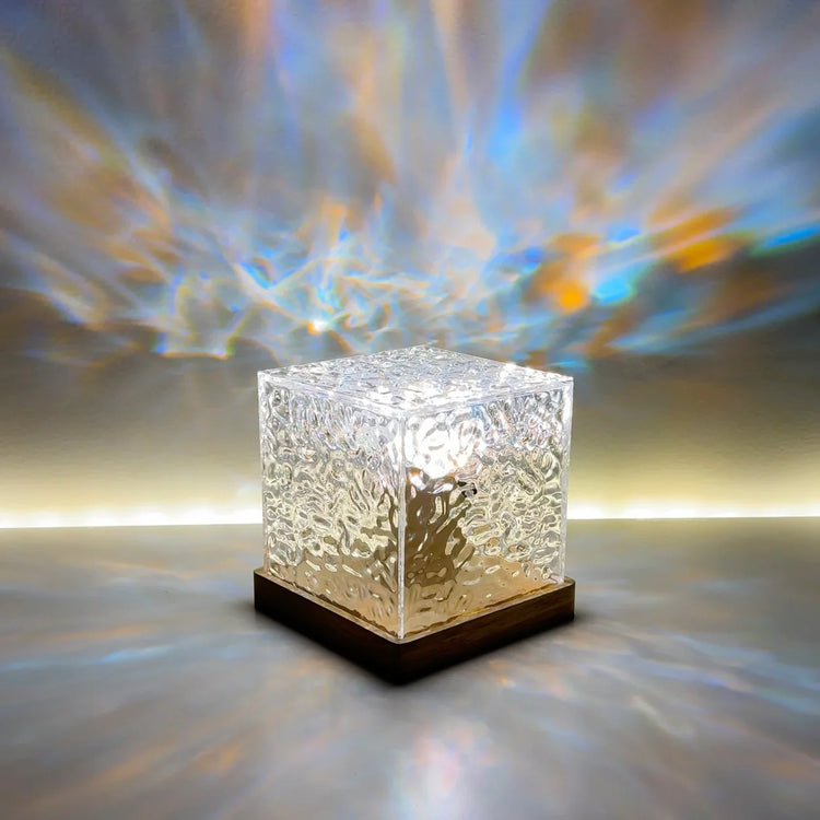 Lumeo Cube lamp die betoverende, kleurrijke lichteffecten creëert op de muur, met een moderne houten basis.