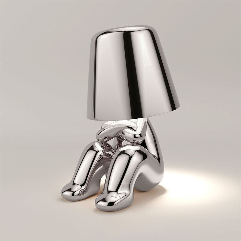 Unieke zilveren Lumineer tafellamp met een artistiek en minimalistisch design, ideaal voor flexibele en sfeervolle verlichting in moderne interieurs.