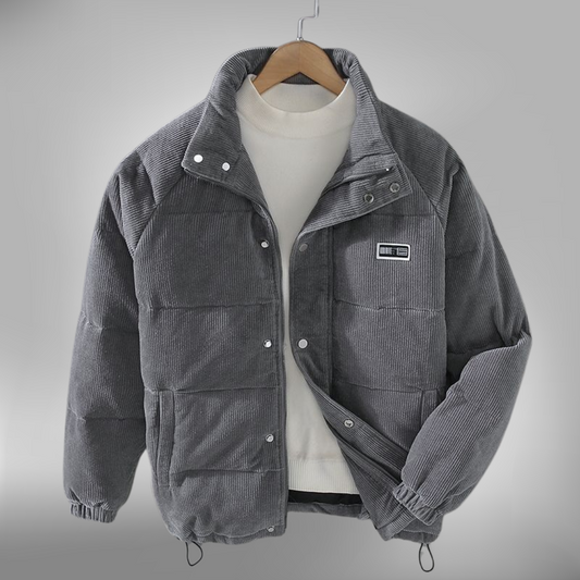 De Borealis winterjas in grijs corduroy biedt zowel warmte als stijl. Het heeft een comfortabele, gewatteerde pasvorm en een praktische ritssluiting met drukknopen. De jas is ideaal voor de koude wintermaanden, met een casual ontwerp en een subtiele merkpatch op de borst. Perfect voor dagelijks gebruik, biedt deze jas zowel bescherming tegen de kou als een modieuze uitstraling.
