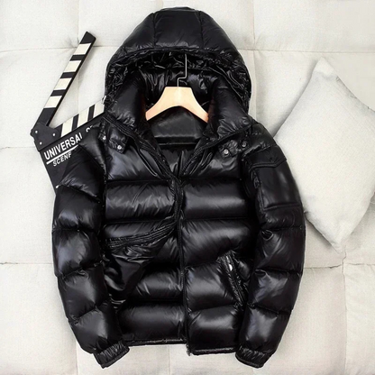 Borstin Winterjas Puffer in glanzend zwart. Deze stijlvolle gewatteerde winterjas met capuchon biedt ultieme warmte en comfort voor koude dagen. Perfect voor heren met een moderne uitstraling.