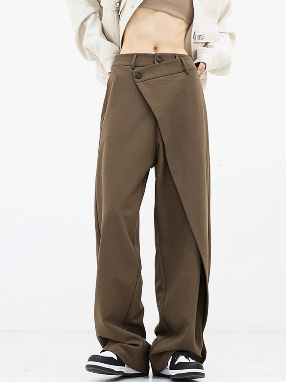 Trendy bruine wijde broek met een asymmetrisch overlappend ontwerp. De hoge taille en losse pasvorm geven een moderne en casual uitstraling. Ideaal voor een stijlvolle en comfortabele look.