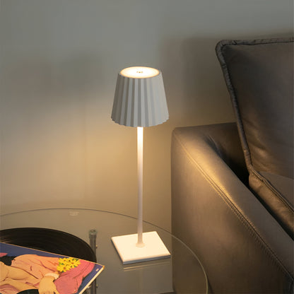 De Gellura LED-tafellamp in een strakke witte afwerking met een plooien lampenkap voegt een modern accent toe aan je interieur. Het verstelbare ontwerp biedt veelzijdigheid, ideaal voor een comfortabele leeshoek of als sfeervolle verlichting naast de bank. Perfect voor eigentijdse woonruimtes.