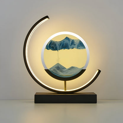 De GlareGlow Sandlamp is een kunstzinnige lamp met een veranderend zandpatroon in blauw en geel, omgeven door een elegante zwart-gouden basis. De lamp creëert een sfeervolle, rustgevende atmosfeer door de zachte verlichting die van de zijkanten uitstraalt. Het moderne design maakt deze lamp ideaal voor het verfraaien van elk interieur.