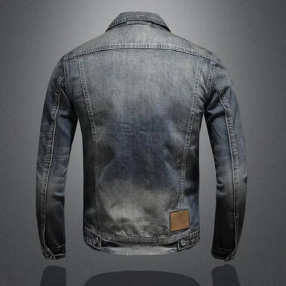 Kavelin spijkerjas in grijs met een vintage gewassen effect. De achterkant van de jas heeft subtiele naden voor een getailleerde pasvorm en een leren labeldetail aan de onderzijde. Een tijdloze en stijlvolle toevoeging aan je garderobe.