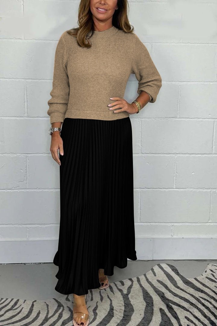 Een stijlvolle, tijdloze pleated jurk van Kendra in zwart met een beige trui-top. De elegante plissé rok voegt een verfijnde flair toe, perfect voor elke gelegenheid.
