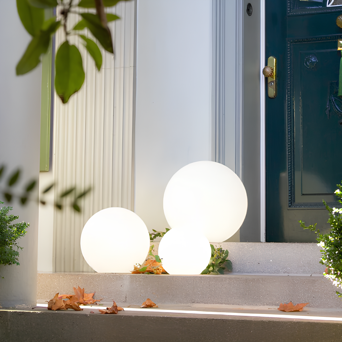 Kendra tuinverlichting met verlichte, sferische lampen langs een trap, die de entree van het huis op een elegante manier verfraaien met een zachte gloed.