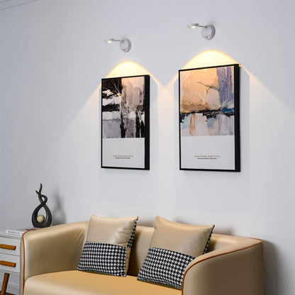 KreativX Motion Spotlight verlicht moderne abstracte kunstwerken aan de muur boven een stijlvolle bank, met zachte en gerichte verlichting.