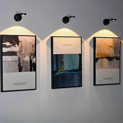 KreativX Motion Spotlight verlicht drie abstracte kunstwerken aan de muur, met sfeervolle, gerichte verlichting die de kleuren en details accentueert.