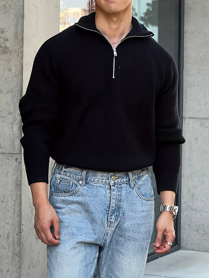 LIVANO heren trui in zwart, met een stijlvolle ritssluiting bij de hals. De trui heeft een geribbelde structuur en wordt gecombineerd met een casual look door de blauwe jeans.