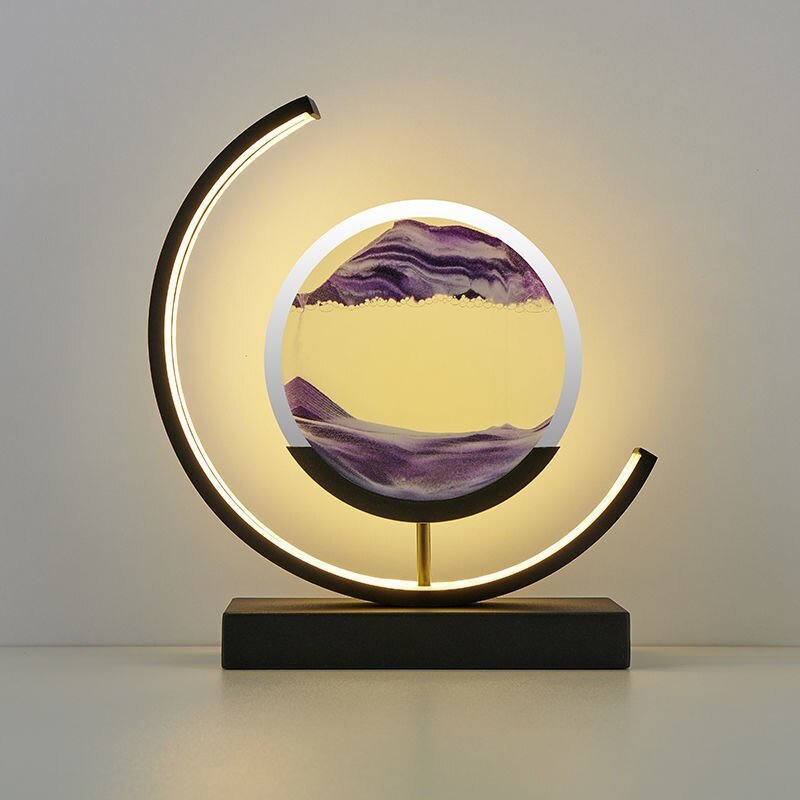 De LumiAura lamp creëert een magische sfeer met een prachtig zandlandschap dat in beweging blijft. Het minimalistische, cirkelvormige ontwerp, verlicht door een zachte rand, benadrukt de hypnotiserende zandstroom in een levendig paars. Deze lamp is niet alleen een lichtbron, maar ook een dynamisch kunstwerk dat rust en elegantie toevoegt aan elk interieur. Perfect voor moderne woonruimtes waar sfeer en stijl centraal staan.