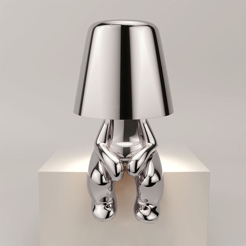 Stijlvolle zilveren Lumineer tafellamp met een uniek en speels ontwerp, perfect voor flexibele verlichting in moderne woon- of werkruimtes.