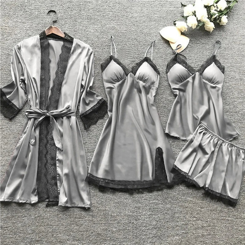 De afbeelding toont het LunaComfort pajamapakket in een elegante grijze kleur. Het set bevat een satijnen nachtjapon, chemise, nachthemd en een bijpassende short, allemaal afgewerkt met verfijnd zwart kant. Dit luxe pakket biedt ultiem comfort en is perfect voor een ontspannen avond.