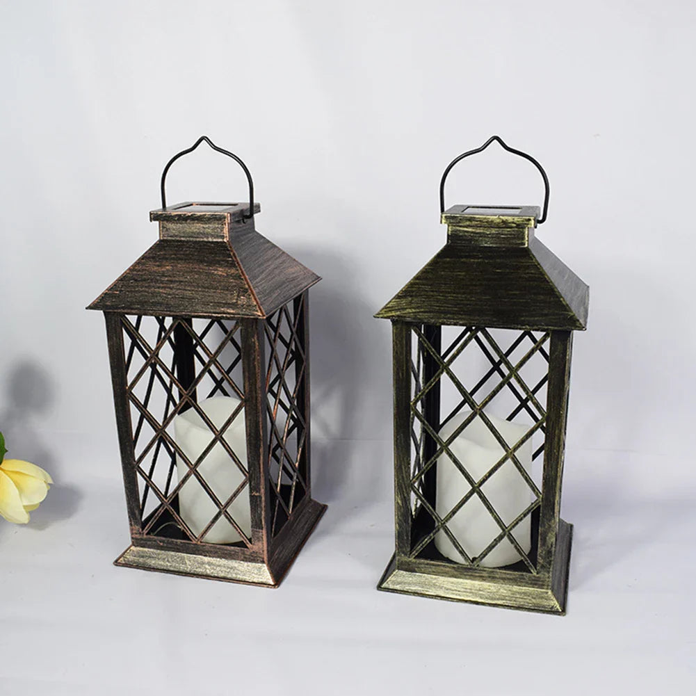 Twee metalen lantaarns met een vintage uitstraling, elk voorzien van een wit kaarsje. De lantaarns hebben een geometrisch ontwerp en zijn afgewerkt in bruine en groene tinten, perfect voor het creëren van een rustieke en sfeervolle ambiance in huis of buiten.