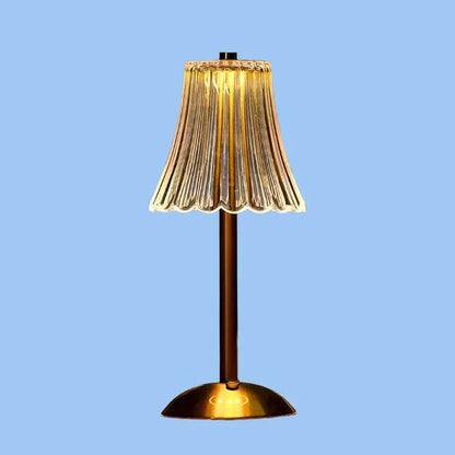 Een stijlvolle draadloze tafellamp met een gouden voet en een prachtig geplooide glazen lampenkap die warm gloeit, waardoor een elegante en moderne sfeer in elke kamer ontstaat.