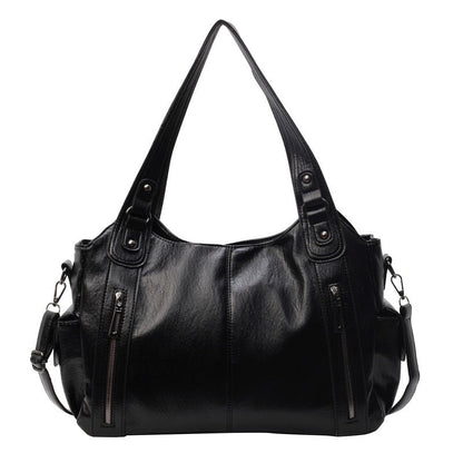 OLYNDA zwarte tote tas met twee ritsvakken aan de voorkant, stevige handgrepen en een schouderriem. Praktisch en tijdloos ontwerp.