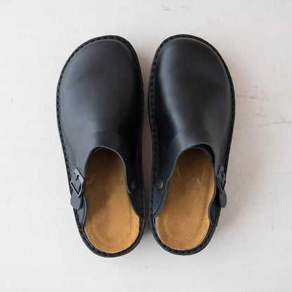 Bovenaanzicht van zwarte leren orthopedische slippers met gespsluiting en comfortabele binnenzool.