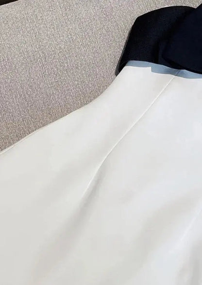 Witte Jurk met Zwarte Strik en Diepe Uitsnede