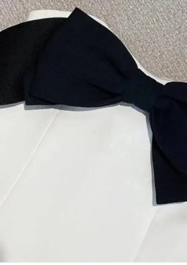 Witte Jurk met Zwarte Strik en Diepe Uitsnede