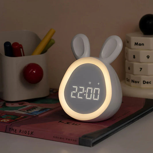 Urania alarmklok in schattig konijnontwerp met oortjes. De klok heeft een digitale LED-display en een zachte nachtlampfunctie. Perfect voor op een nachtkastje of bureau, ideaal voor kinderen en volwassenen.