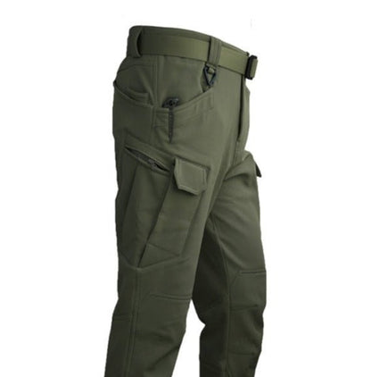  Een close-up van de olijfgroene Zenova RegenSet broek, met praktische rits- en cargozakken en een riem bij de taille, perfect voor buitenactiviteiten.