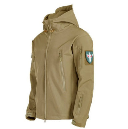 Een zandkleurige waterdichte regenjas met een capuchon en meerdere ritszakken, inclusief een militair geïnspireerd embleem op de mouw. De jas biedt zowel praktische functionaliteit als een stijlvolle uitstraling, ideaal voor het weer en avontuurlijke buitenactiviteiten.