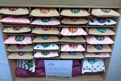 Een adventskalender met 24 kleurrijk verpakte zakjes, elk voorzien van een nummer en een vrolijk patroon. De kalender biedt een dagelijkse verrassing en is perfect voor de feestdagen, ideaal voor het creëren van een magische sfeer. Het ontwerp bevat zakjes met verschillende kleuren en stijlen, waaronder stippen, sterren en chevron patronen, die de kalender een speelse en betoverende uitstraling geven.