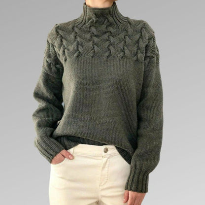 Zimora veelzijdige casual trui in donkergroen, met een stijlvol gevlochten patroon rond de schouders en hoge kraag. De trui heeft een comfortabele pasvorm en lange mouwen, ideaal voor een warme en trendy look tijdens koudere dagen. Perfect te combineren met jeans of lichte broeken voor een casual, maar modieuze uitstraling.