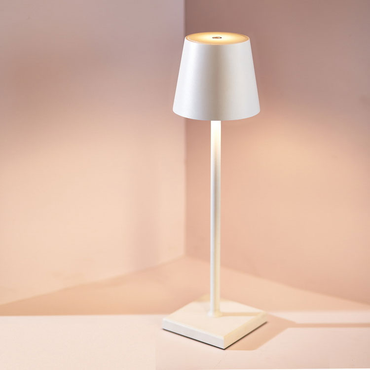 Een moderne draadloze tafellamp met een strakke witte basis en een minimalistisch, conisch lampenkapje. De lamp heeft een elegante uitstraling en biedt subtiele verlichting, perfect voor een stijlvolle en praktische toevoeging aan elk interieur.
