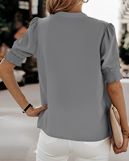 Blouse met een stijlvolle V-hals en trendy korte mouwen. Een veelzijdige aanvulling op je garderobe met een perfecte balans tussen casual en professioneel. Gemaakt van luchtige chiffon en duurzaam polyester voor comfort en stijl. Voorzien van een flatterende V-hals, pofmouwen en een losse pasvorm voor bewegingsvrijheid. Maattabel beschikbaar voor borst, lengte en mouwen.