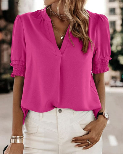 Blouse met een stijlvolle V-hals en trendy korte mouwen. Een veelzijdige aanvulling op je garderobe met een perfecte balans tussen casual en professioneel. Gemaakt van luchtige chiffon en duurzaam polyester voor comfort en stijl. Voorzien van een flatterende V-hals, pofmouwen en een losse pasvorm voor bewegingsvrijheid. Maattabel beschikbaar voor borst, lengte en mouwen.